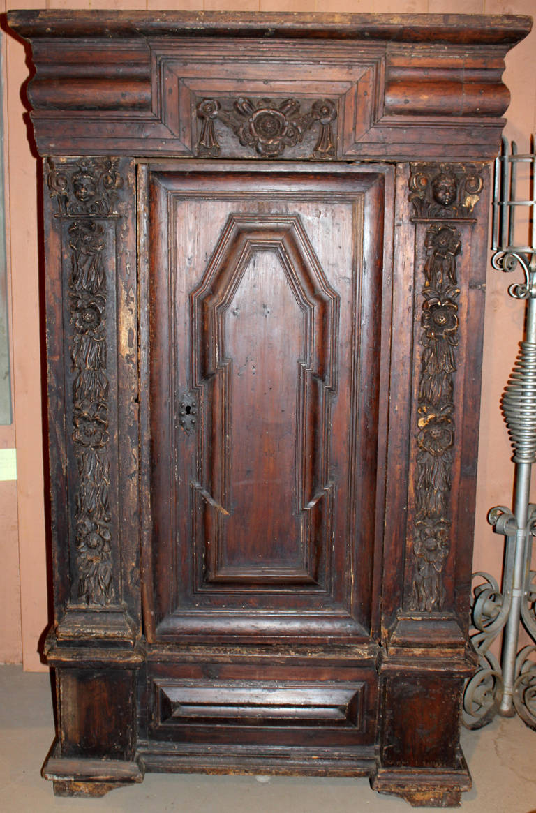 Beautiful carved Continental armoire with carved pilasters and capitols and nicely paneled door. Nice overall patina and molded crest. 16th century/ Restored. Rebuilt in the 19th century from early elements.