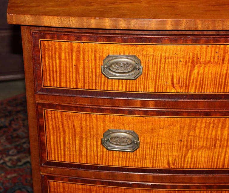 This rare New England four-drawer Federal Hepplewhite style cherry chest of drawers has superb tiger maple drawers with banding and string inlay, beautifully proportioned flared feet, and original stamped brass hardware marked 