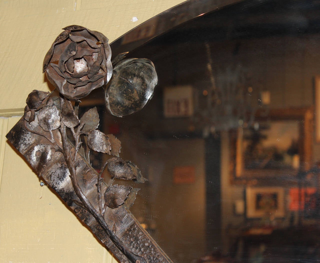 Metalwork beveled glass mirror in the shape of a folding fan, with floral decoration on the left border. 20th century.