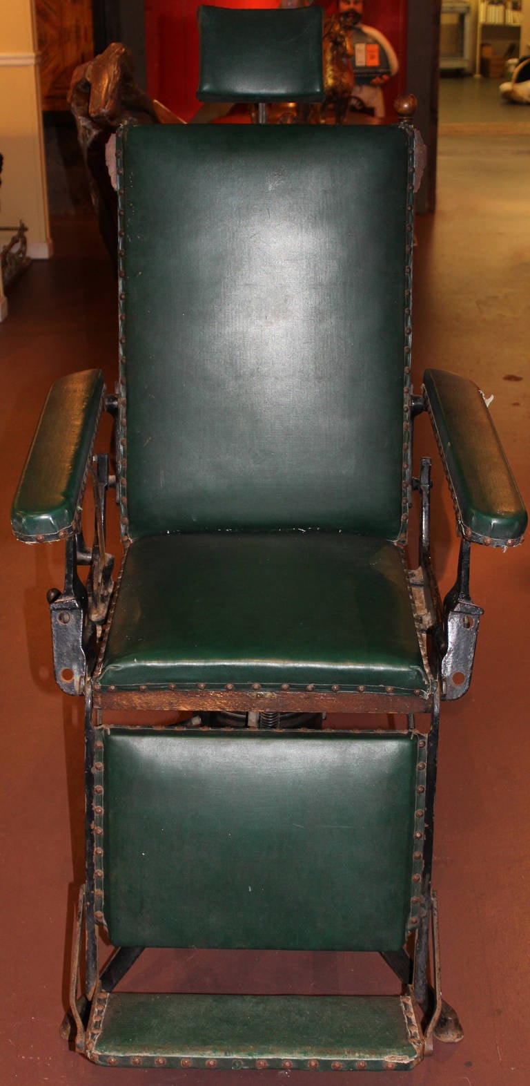 Fantastic late 19th / early 20th century medical or surgical chair manufactured by A. McDannold of St. Louis, MO, signed on base stretcher. Iron adjustable chair base with green leather covered wooden seat and back, carved decoration on seat back,