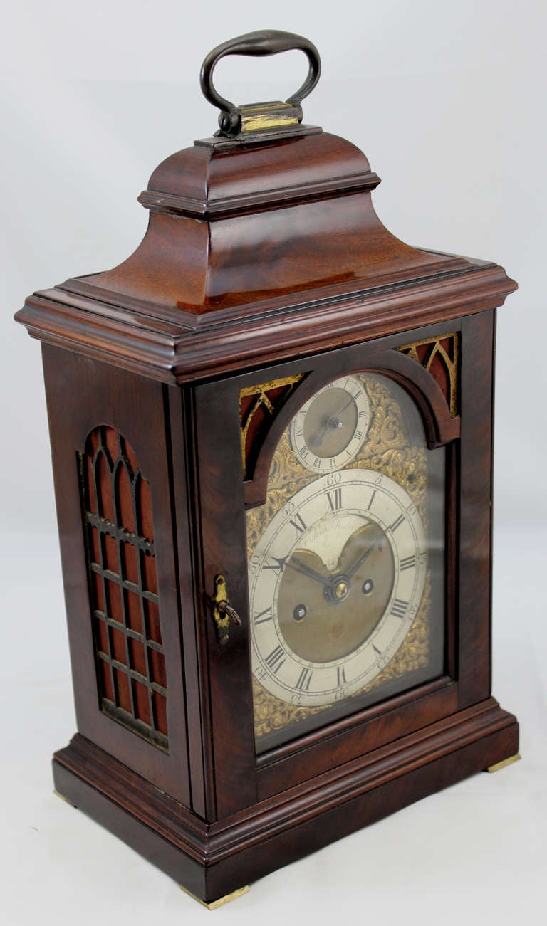 This English mahogany table or bracket clock with bail handle is circa 1765, with a  composite brass dial with recessed 4 ½” maker's boss marked Edward Foster, London.. It has a Roman numeral chapter ring with calendar ring engraved 1-31 around the