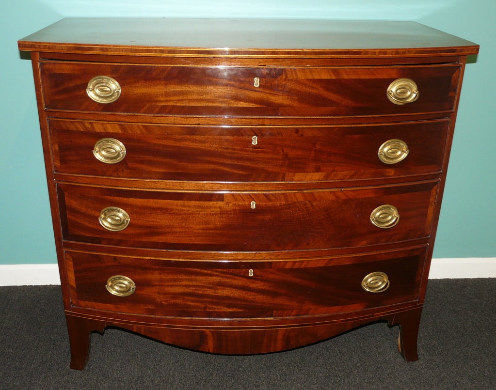 Elegant mahogany swell-front chest featuring four graduated drawers with banding. Circa 1790-1820. All raised on nicely proportioned French feet. Nicely polished.