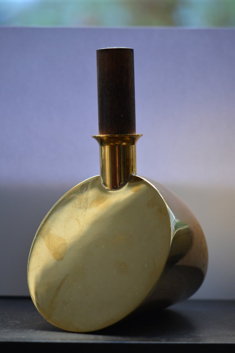 One large brass and wood decanter/alchohol flask.
Looks like the crescent candlestick listed on the set of 9 and set of 11 on my page.