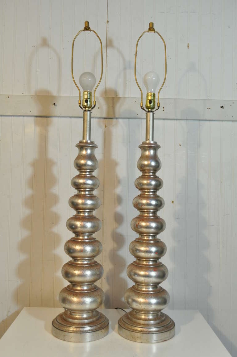 Pair of vintage mid century modern / hollywood regency carved wood column form table lamps. The lamps have a very nice distressed silver toned finish, with matte silver toned socket shafts. (LISTING DOES NOT INCLUDE SHADES)