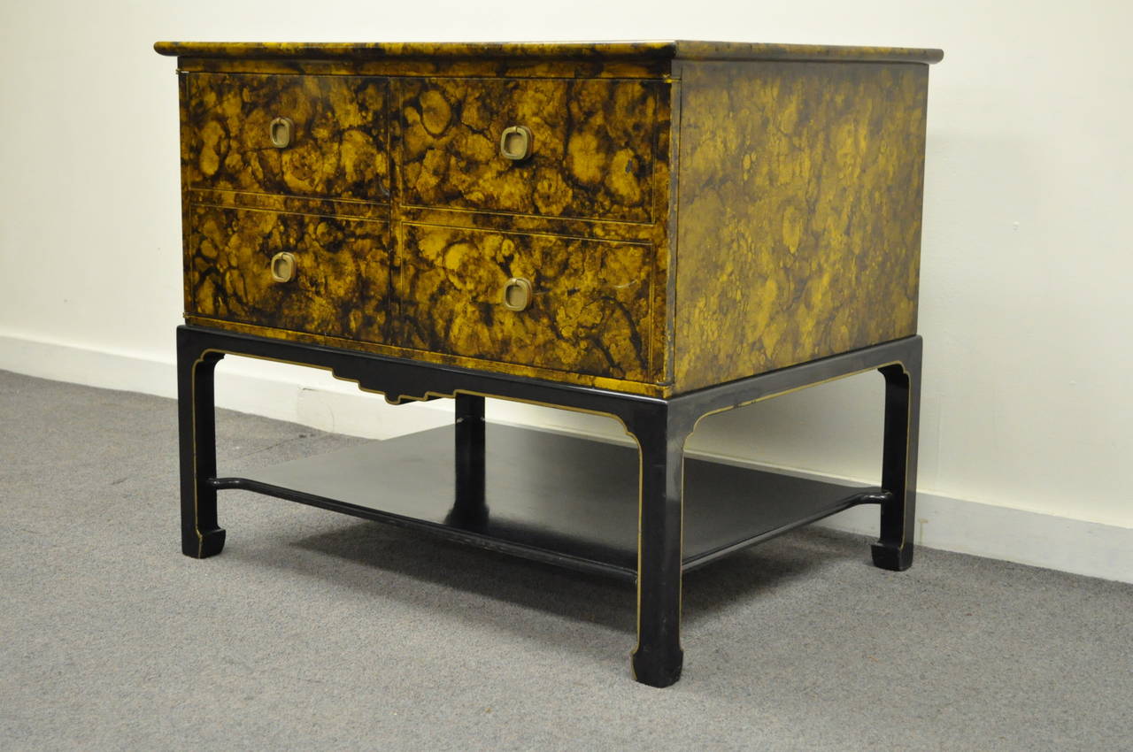 Very unique, vintage, chinoiserie or Hollywood Regency, two-door cabinet with the original faux tortoise or oil drop finish. Item features four brass drop pulls, lower ebonized shelf with interior shelving, gold gilt trim and a very attractive