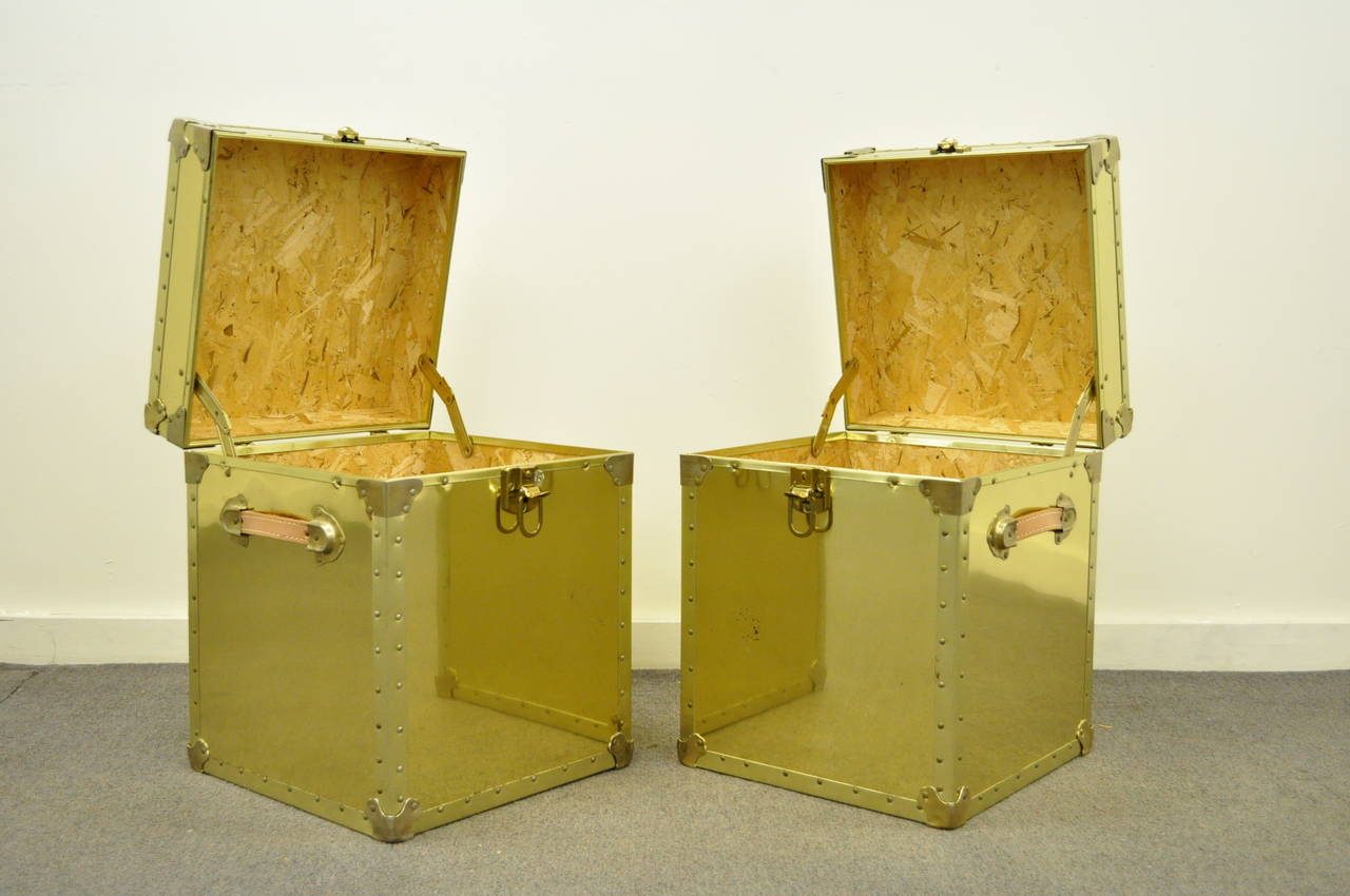 Very unique pair of vintage brass clad trunks or side tables made in the USA by The Luggage Gallery. The pair features natural leather handles. nail trim, wood lined interiors, working locks with keys, and great functionality. They can be used as