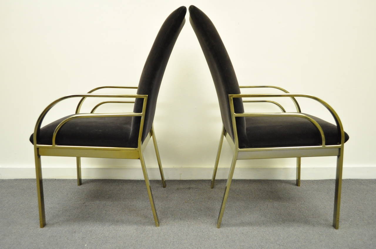 Very unique pair of vintage, brass-plated, Hollywood Regency armchairs in the manner of Pierre Cardin. The pair features sculpted metal frames, angled backs, and great Art Deco and Mid-Century Modern form. The arm height is 23.5