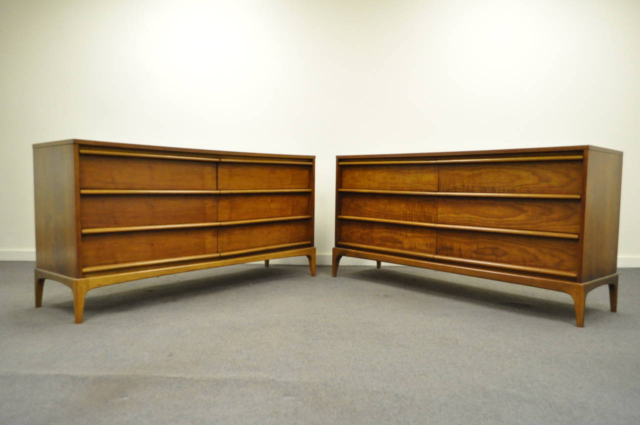 Beautiful  matched pair of Vintage, Mid Century Modern, dressers in the Danish style by Lane. The pair features six dovetailed drawers each, angled and tapered legs, sculpted wood drawer pulls, banded tops, and stunning walnut wood grain throughout.