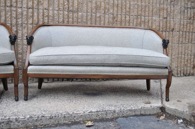 Unique pair of mid 20th Century Figural Settees having Rams head arms and curvaceous legs ending at hoof form feet. These remarkable barrel back settees are constructed of solid mahogany and have great modernist form in the French Regency / Empire