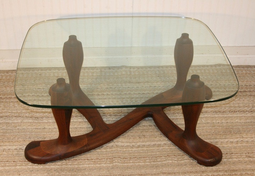 Fabulous 1960s Mid-Century Modern studio crafted solid walnut coffee or cocktail table with a thick rounded edge glass top. This amazing sculptural piece is believed to be of Danish origin and beautifully constructed and finished. The style is in