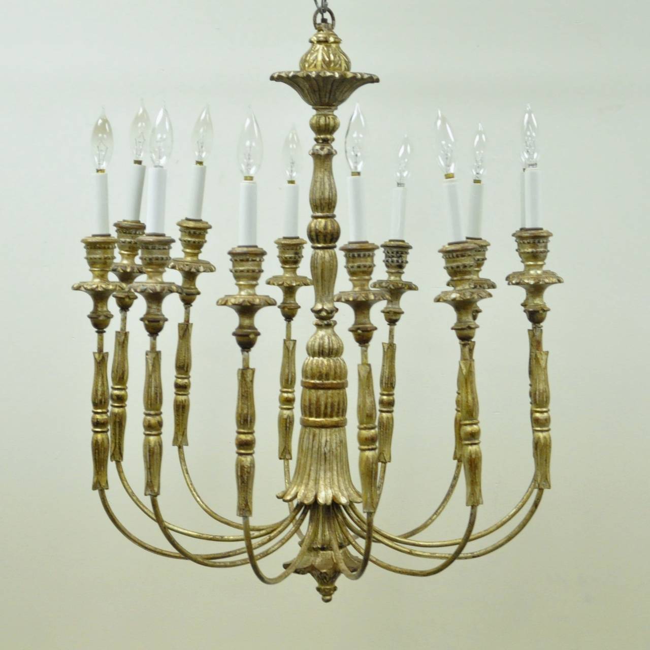 Beautiful Vintage Italian Gilt Carved Wood & Iron Chandelier in the Neoclassical taste. This stunning 12 arm chandelier features a carved and decorated center shaft, with equally impressive, carved wood bobeches and arm detailing. The fixture is
