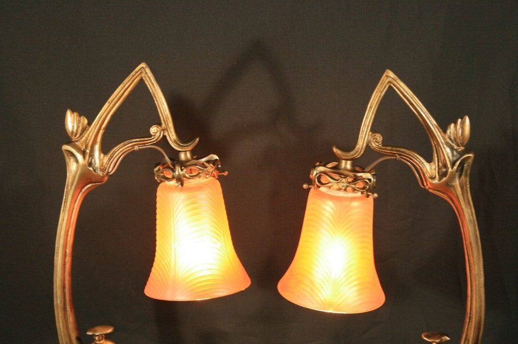 Exceptional pair of Antique Bronze Art Nouveau Tulip Table Lamps with colored rib glass shades in the Tiffany Style. To find a pair of these lamps is impossible and the condition and quality along with weight of these lamps is remarkable. There is