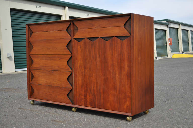Remarkable Mid Century Modern Cabinet/Dresser designed by Marc Berge for Grosfeld House. The item features, seven dovetailed drawers with a flip top hidden mirror, and lower cabinet with swing doors and shelves all on rolling casters. The item has