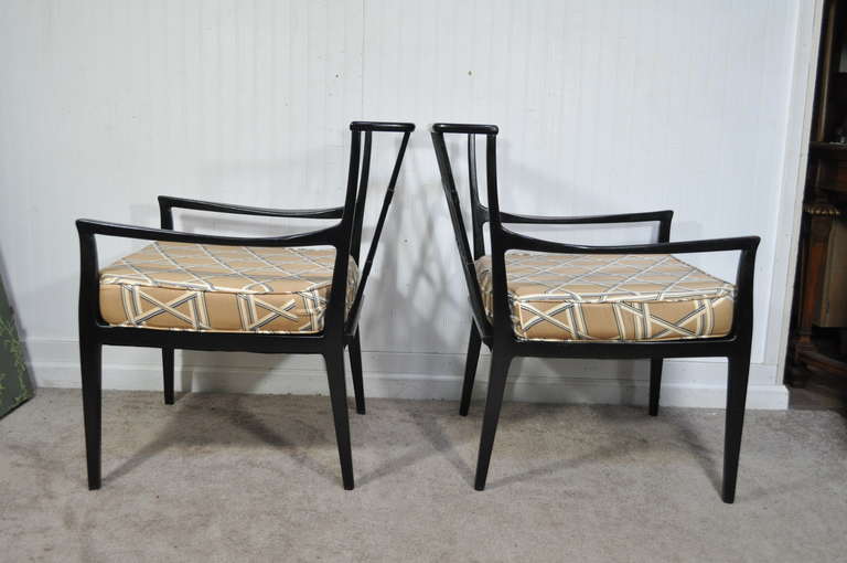 Stunning and sleek pair of vintage ebonized Danish Modern style lounge chairs featuring clean modernist lines, tapered legs, cross jointed lattice barrel backs, slopped arm rests, and very elegant shapely solid wood frames. The chairs are unmarked