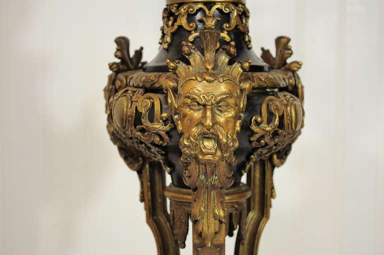 Stately 19th C. French Gilt Bronze Figural Candelabra Lamp in the French Empire Taste. Item features Six ornate candelabra arms, double lights, black insert, ornate gilt bronze detailing with three bearded male faces and detailed paw feet. The lamp