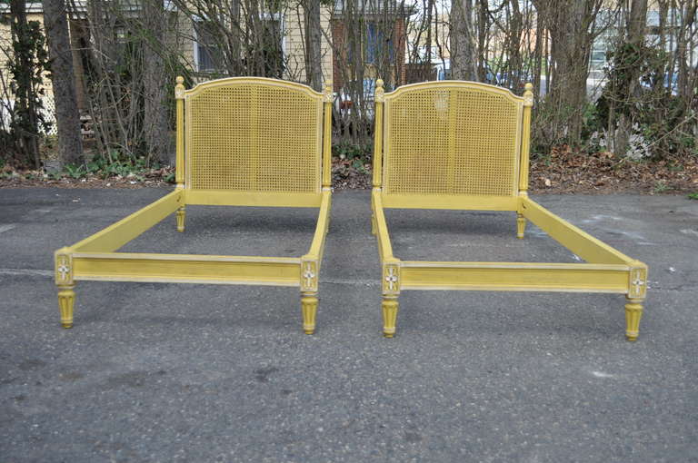 Pair of Adorable Vintage French Louis XVI Style Distress Painted Yellow Cane Back Custom Made Childrens'/Toddlers' Beds. The beds feature a desirable distressed yellow with white trimmed finish, carved florets at the joints, fluted column form legs