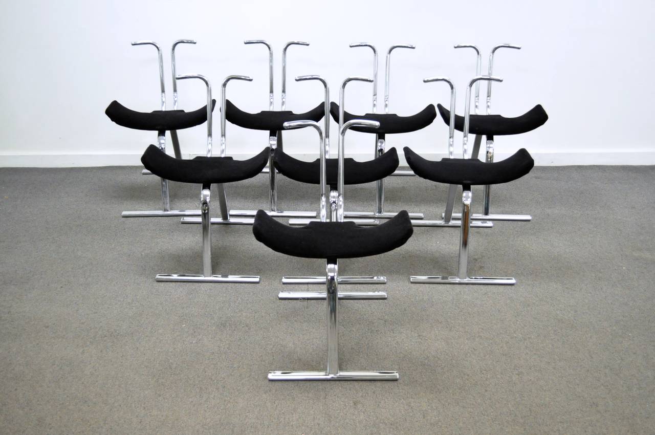 Rare set of eight chrome stacking dining or game chairs by Stendig. The chairs have a great Silhouette, with super sleek tubular chrome construction, and slightly upturned black seats. Perfect for dinner parties or game nights when you need unused