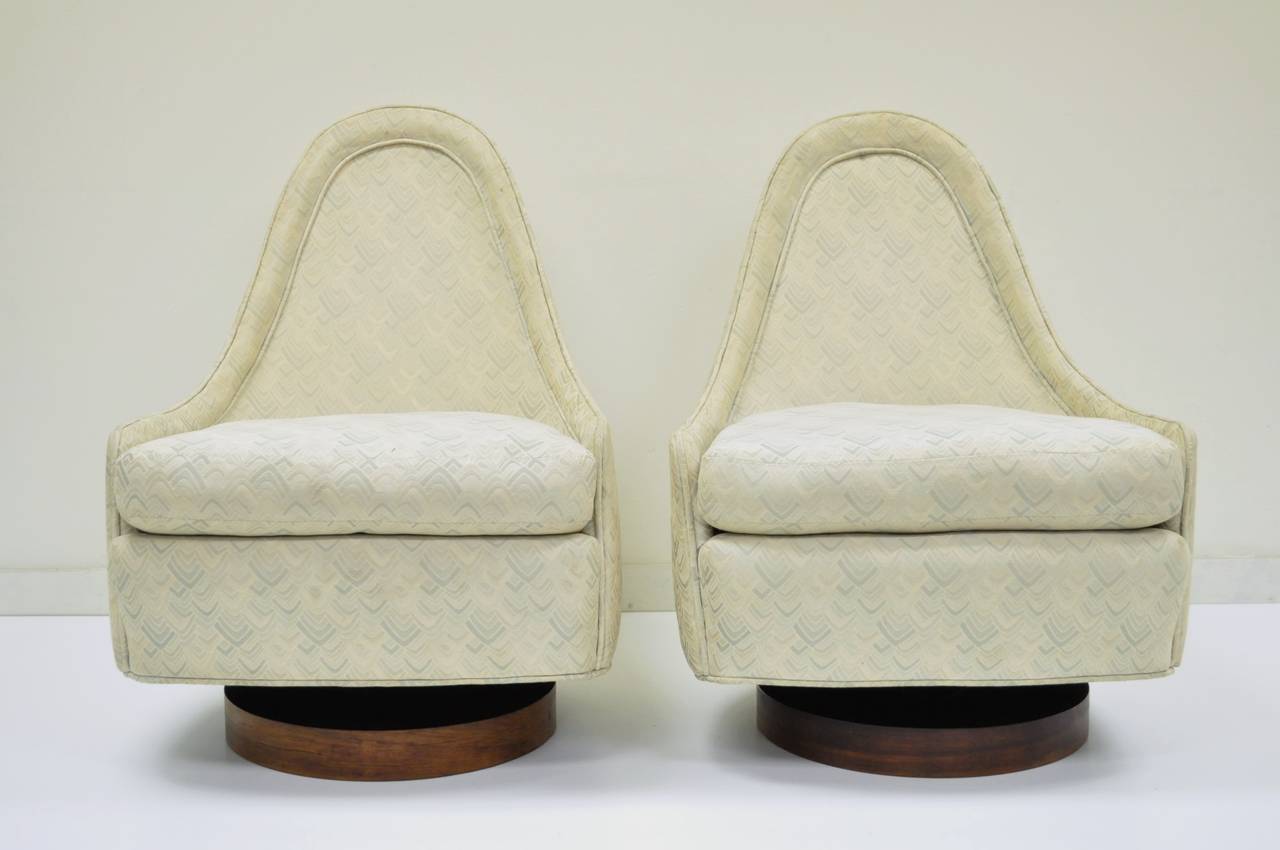 Pair of rare mid century modern petite/children's swivel lounge chairs by Milo Baughman for Thayer Coggin. The chairs feature sculptural teardrop backs, solid walnut plinth bases, and a wonderful all around modern form. The chairs measure 28.5