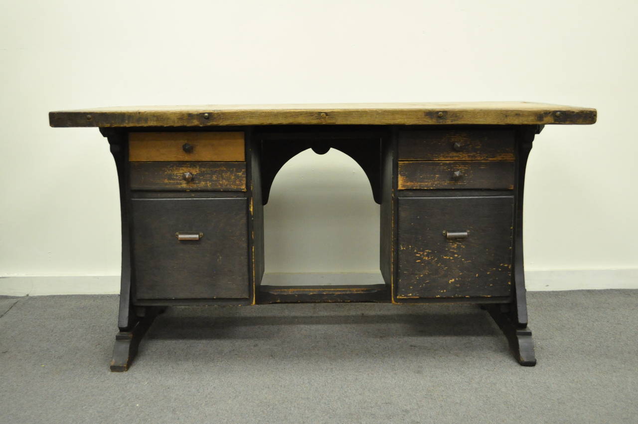 Unique mission style handcrafted kneehole writing desk, dating back to the early 20th century. The desk features a two-toned top, quatrefoil cut-out accents, six drawers (two file-sized), and a very appealing age distressed finish. The piece is very