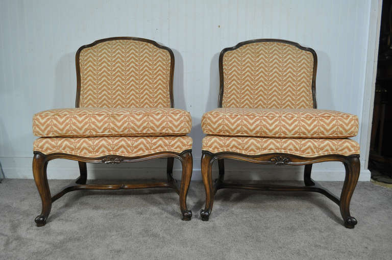Beautiful Pair of Vintage French Louis XV Style Carved Walnut Stretcher Base Slipper Chairs with attractive neutral fabric and loose cushions. Item features delicately carved solid wood frames,  cabriole legs, great comfortable form , and classic