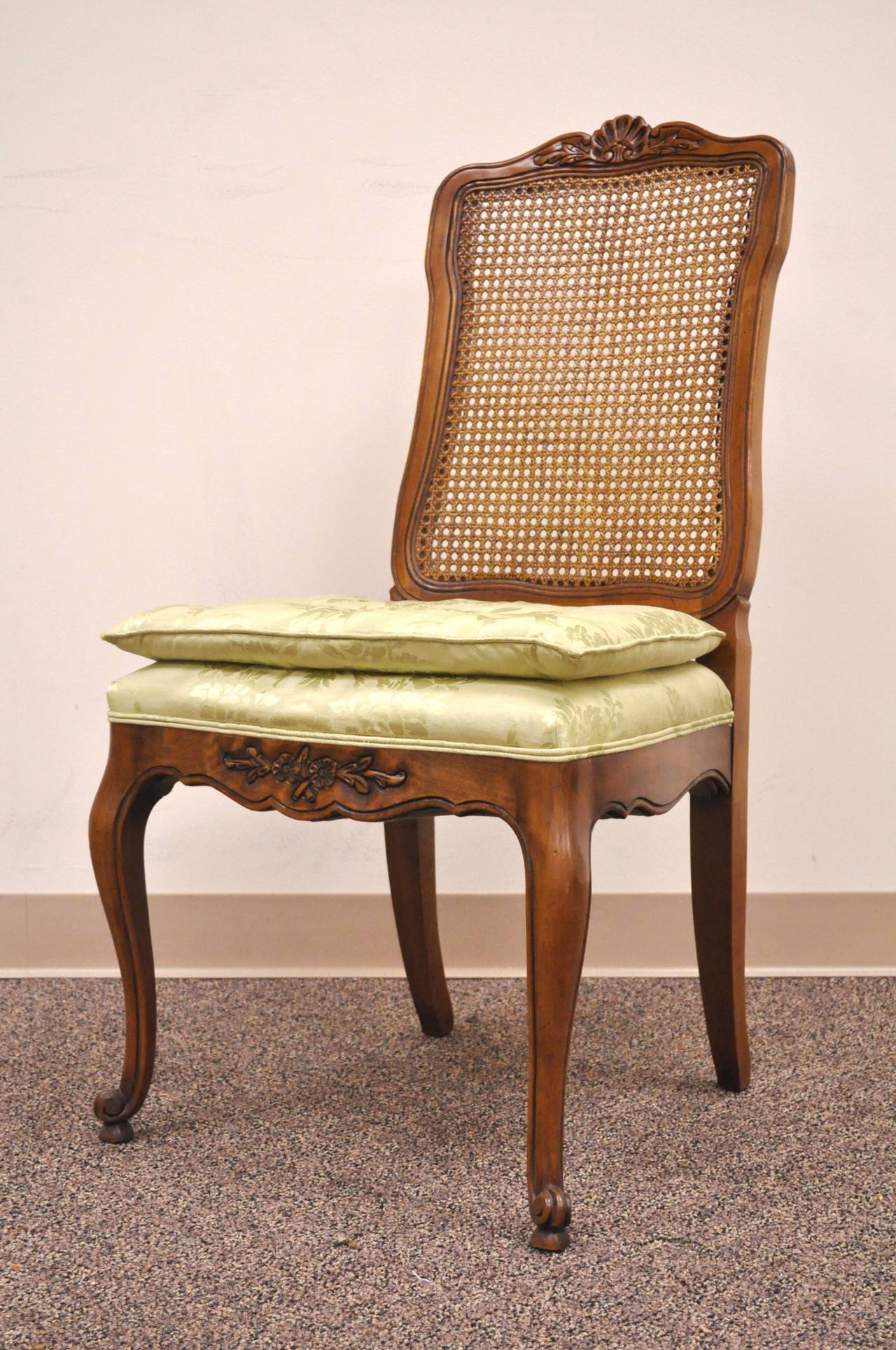 A set of French country/Louis XV style dining chairs by Kindel Furniture Co, including two armchairs and six side chairs. The chairs are very handsomely carved solid wood, with floral accents and shapely cabriole legs. The side chairs have caned