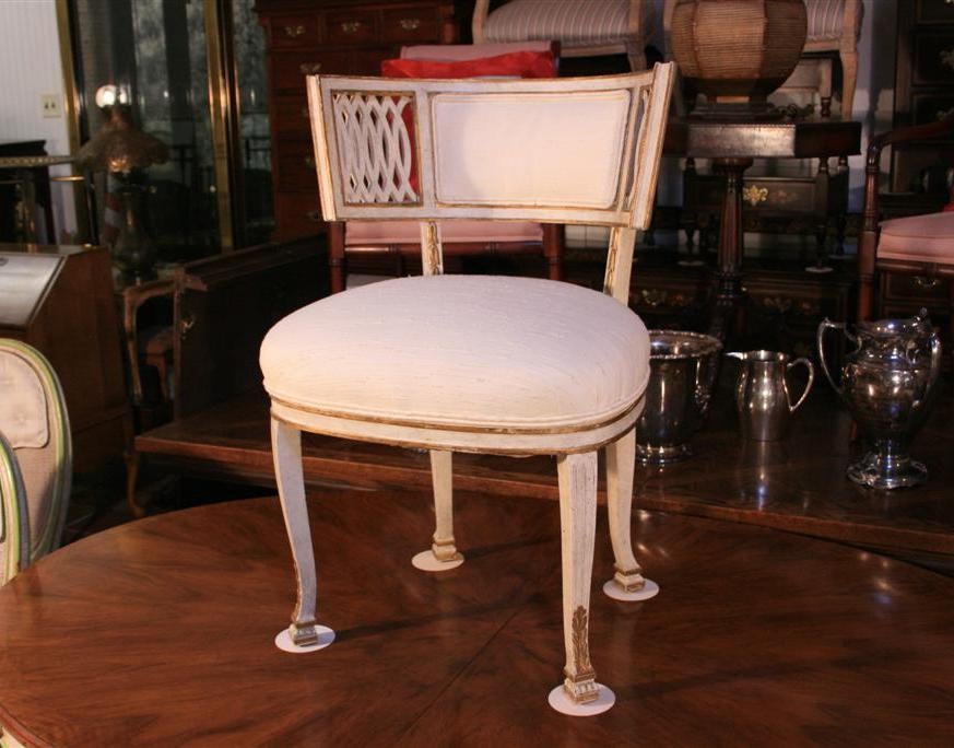 French Style side or accent chair in the Manner of Maison Jansen. Chair features curved and pierce carved back, parcel gilt, antiqued off white paint decoration, curvaceous legs, and poofed raw silk or linen upholstered seat and back.