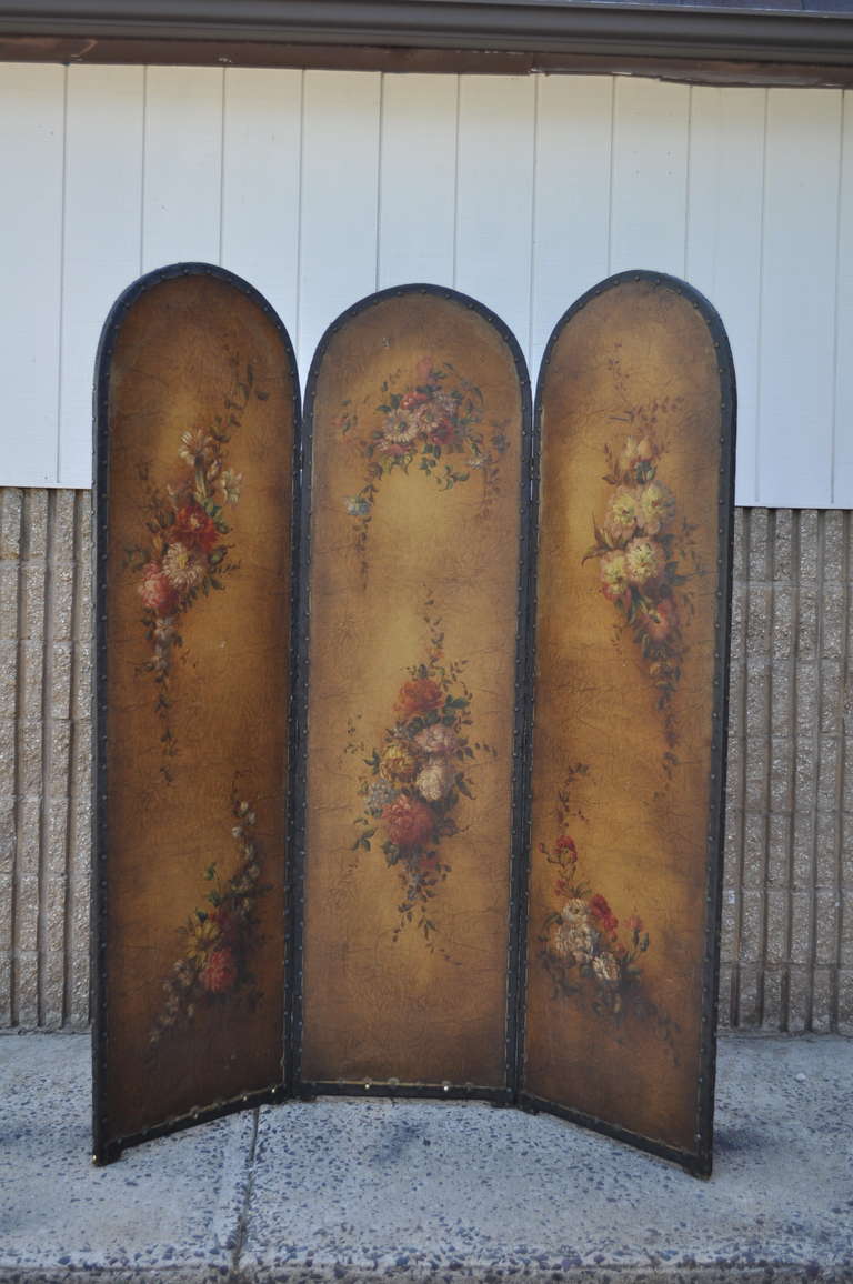 Fantastic French 3 Panel Hand Painted Oil on Canvas (some say on leather but I believe it to be canvas) Dressing Screen Circa 1920. This beautiful screen features leather trim and nail head border, and very well done hand painted flowers on the