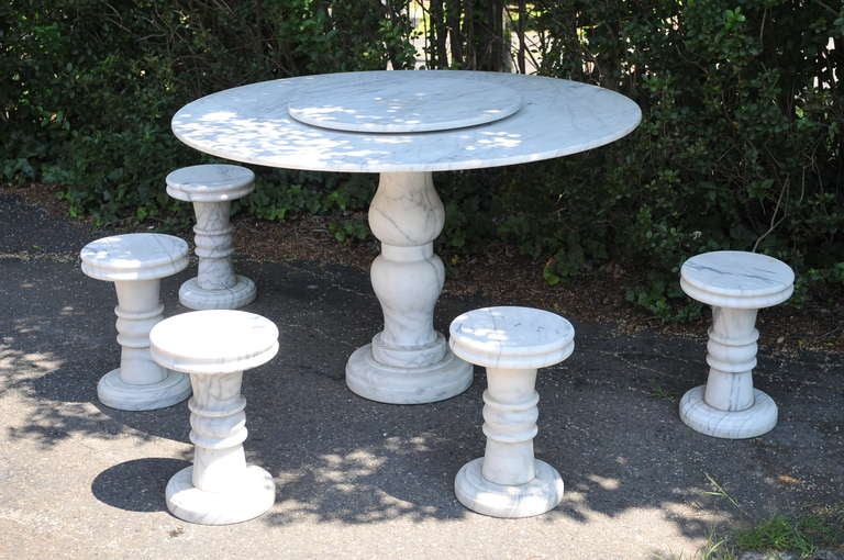 Very unique 6 piece solid carved marble neoclassical style garden set consisting of a round dining table with removable lazy susan center piece and 5 column form stools. Table measures 30