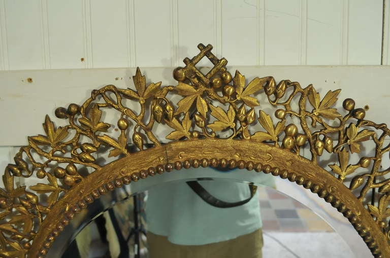 Remarkable French 19th C. Bronze Foliate Round Neoclassical Wall Mirror / Sconce with 5 Decorative Arms for Candles and a Beveled Glass Central Mirror. Item features wonderful leafy design surrounding the frame and ornate scrolling arms.