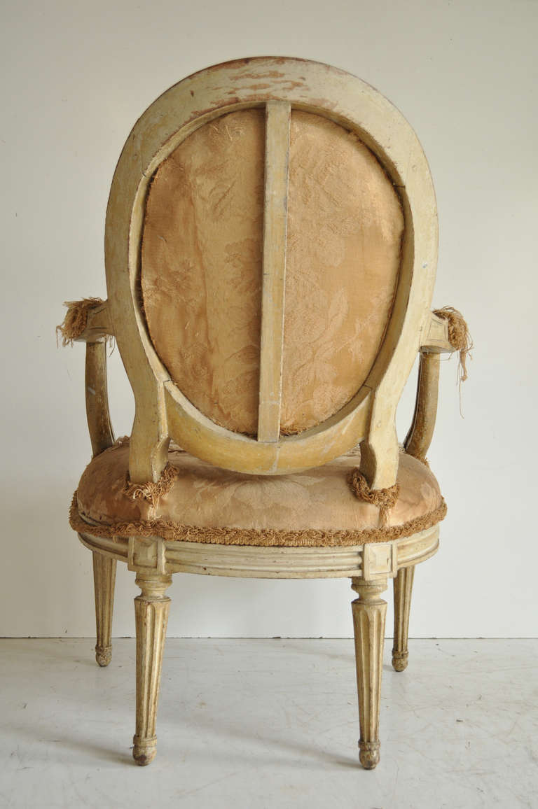 Beautiful Antique French Louis XVI Style Carved Oval Back Fireside Arm Chair. The piece is extremely well constructed with a stretcher supported oval back, and features wonderfully carved scroll work arms and fluted column-form legs. The authentic