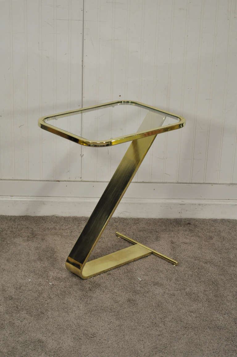 Quality vintage brass and glass small Z Form side table after Milo Baughman. Table features a sleek modernist frame, inset rounded edge glass top, and small spherical feet. The table has nice weight and is very well constructed.