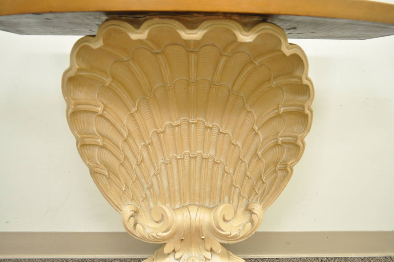 Stately shell form console table attributed to Grosfeld House. This unique item features a shaped wooden top over a glorious cast plaster shell form base.