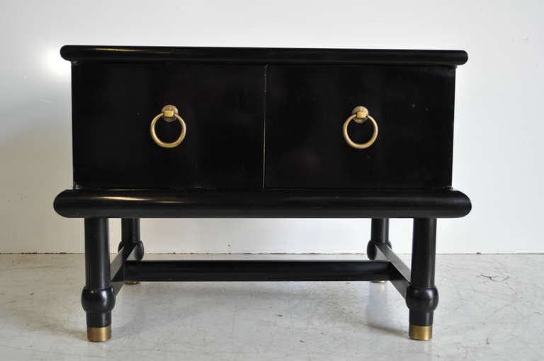 Very unique stretcher base ebonized side cabinet or end table with the most stunning onyx top. The table features an inset onyx stone top, brass capped feet, brass round drop pulls, stretcher base, and attractive styling in the manner of Dorothy