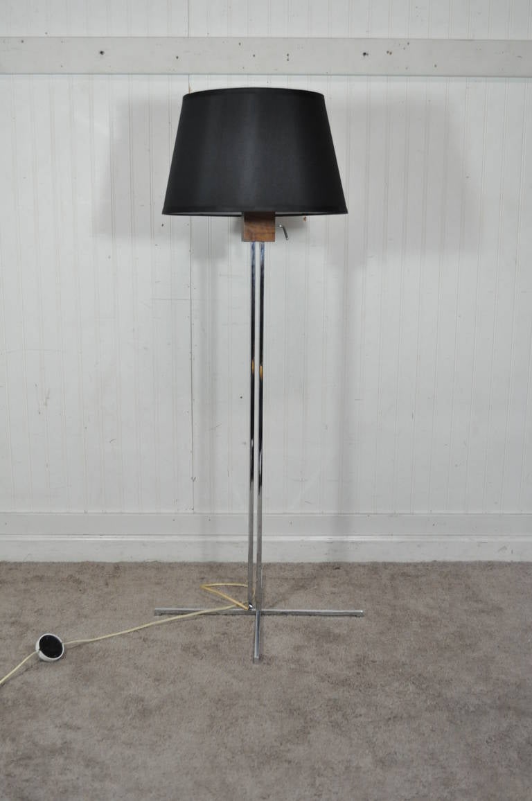 Very unique adjustable height chrome and walnut Swiss floor lamp designed by Hans Eichenberger. The lamp features a very sleek chrome frame with four raised step down feet, and three light sockets. Very clean modernist design. Shade shown for affect