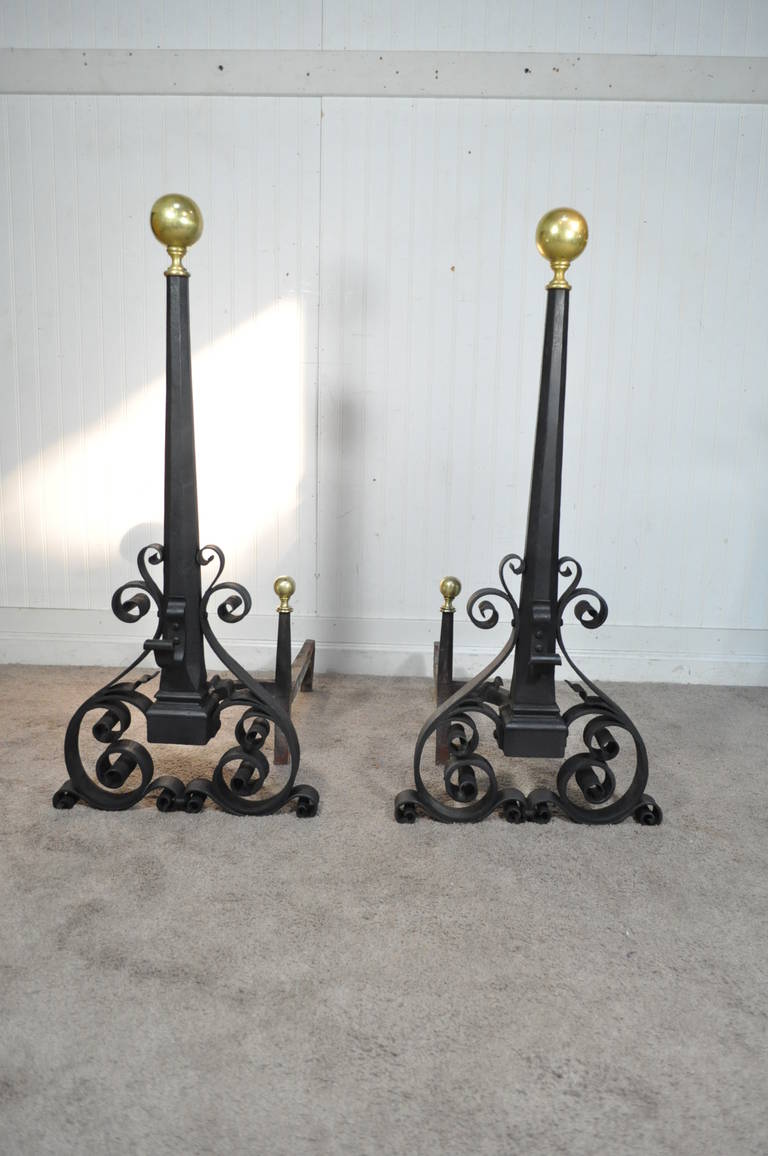 Stately pair of hand-wrought iron and solid brass finial andirons with matching cross bar. This important set features scrolling iron work, solid brass finials and substantial size. All three pieces sold together. Andirons measure 35.75