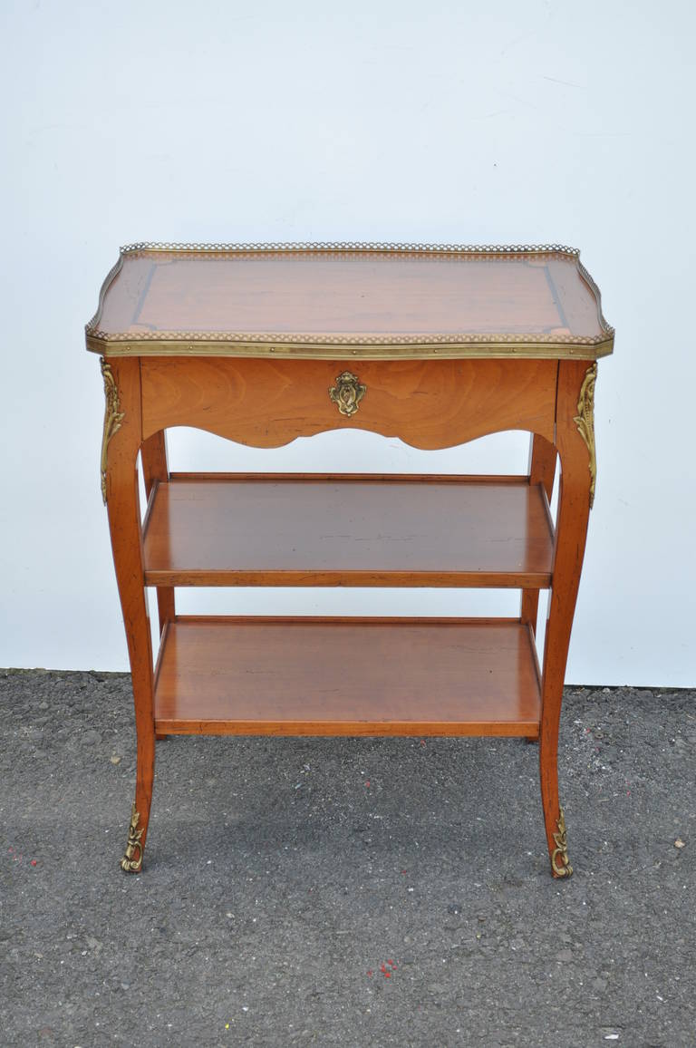 Remarkable Quality French Side Table with single drawer and bronze ormolu in the Louis XV / French Country Taste. The item features superior quality solid cherry wood construction with a single dovetailed drawer, inlaid top, exposed pinned joints,