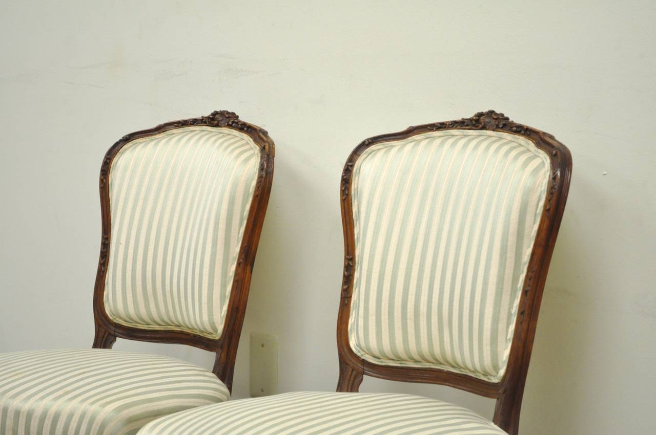 Bemerkenswertes Paar handgeschnitzter französischer Beistellstühle aus Nussbaumholz aus dem 19. Jahrhundert im Stil von Louis XV. Das Paar zeichnet sich durch geschnitzte Cabriole-Beine, schwere, floral geschnitzte Rahmen aus massivem Nussbaum und