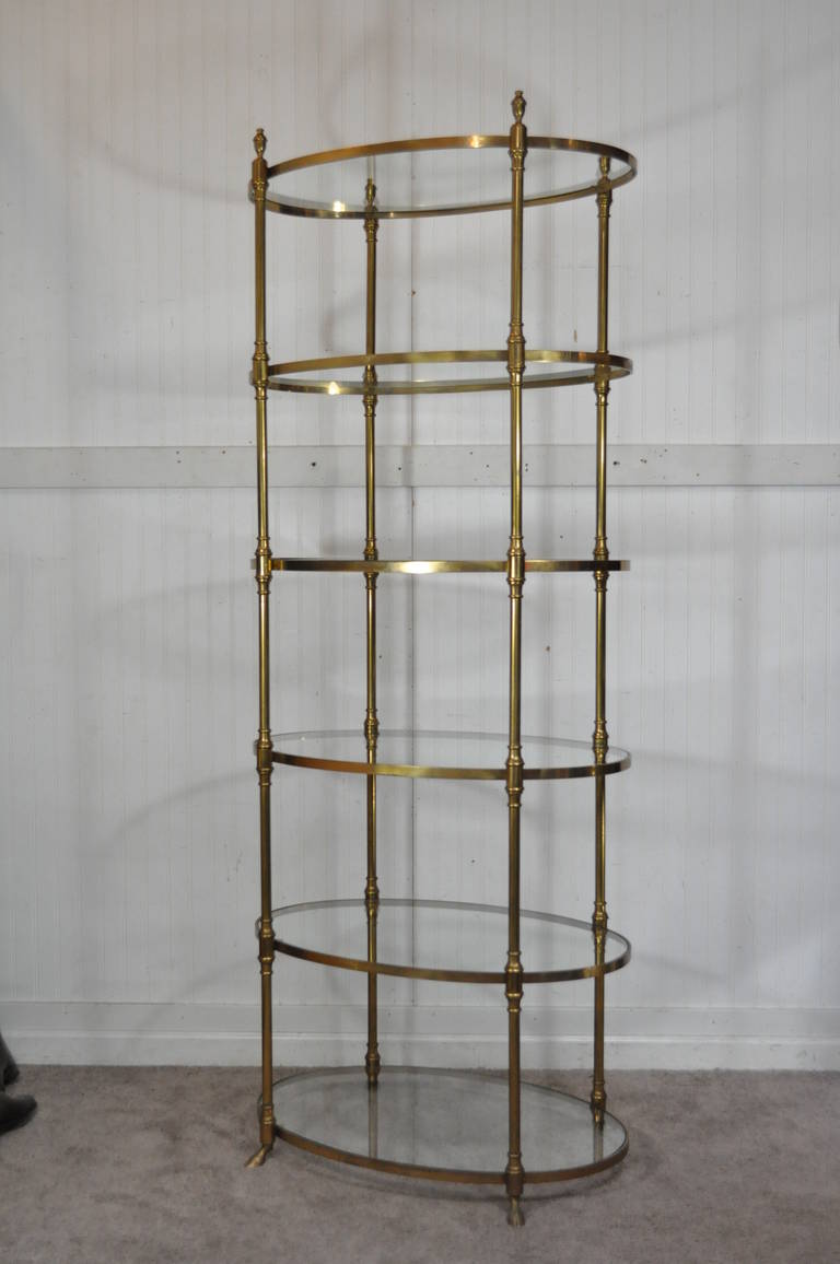 Very rare Italian Etagere by Labarge. Item features a very nice solid burnished brass ovoid frame with 6 glass shelves, hoof feet, urn form finials, with classy and elegant styling.