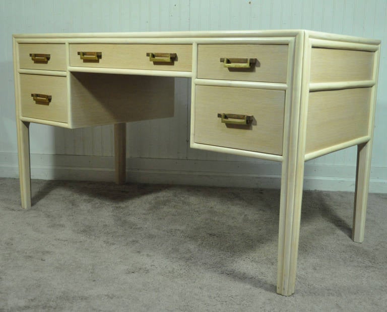 Striking Vintage Mid-Century Modern Combed Solid Oak Five-Drawer Writing Desk by McGuire. The piece features a lovely off-white finish, stylized faux bamboo legs, solid brass drawer pulls, and a very nice wood grain throughout. Very nice quality
