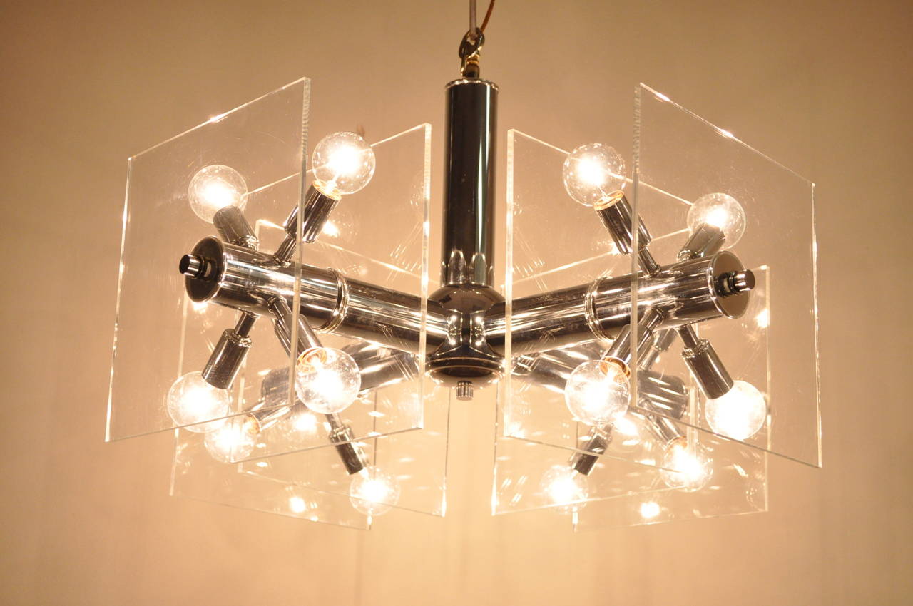 Remarkable vintage lucite and chrome sputnik chandelier. This fantastic light fixture features a mirror finished chrome plated frame, four arms with four lights per arm extending from sputnik style sockets. Each of the arms features two clear lucite