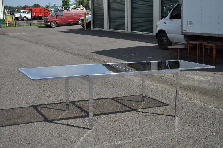 Very Sleek Vintage Polished Chrome and Smoked Glass Extension Dining Table attributed to Milo Baughman. The table features a polished chrome, seamless joined frame and inset smoked glass tops. There are pull out extensions on either side of the