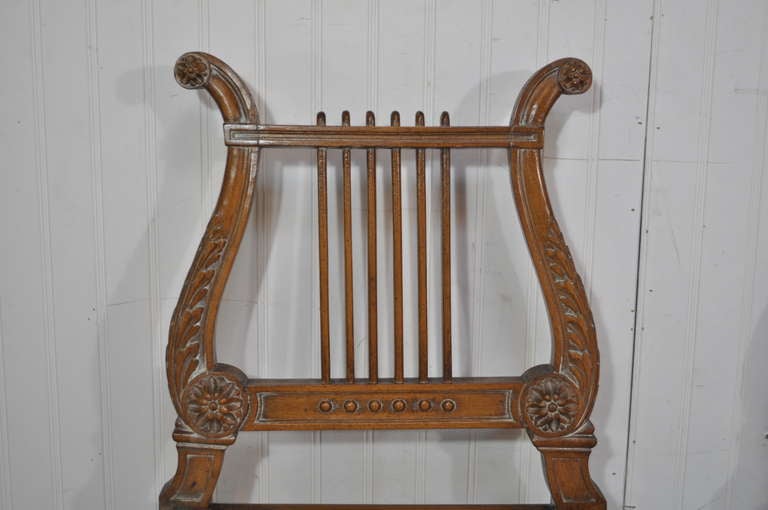 Pair of Italian carved lyre back side chairs in the French neoclassical style. The pair features cane seats, shapely saber legs, finely carved lyre backs and classical form. Chairs marked 
