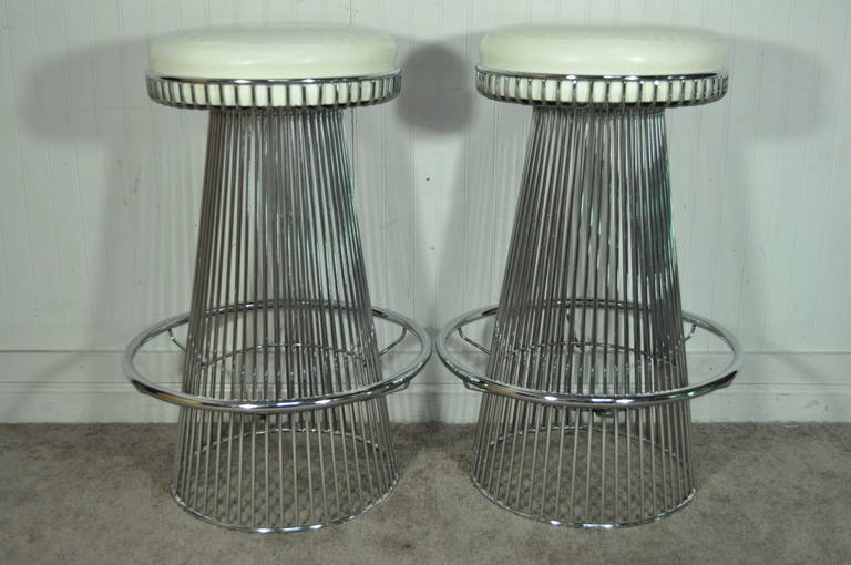 Very rare pair of heavy vintage wire frame chrome bar stools by Contemporary Shells Inc., of NY in the manner of Warren Platner. The pair features tapered wire frame chromed bases with footrests and inset original vinyl cushions. Each stool measures