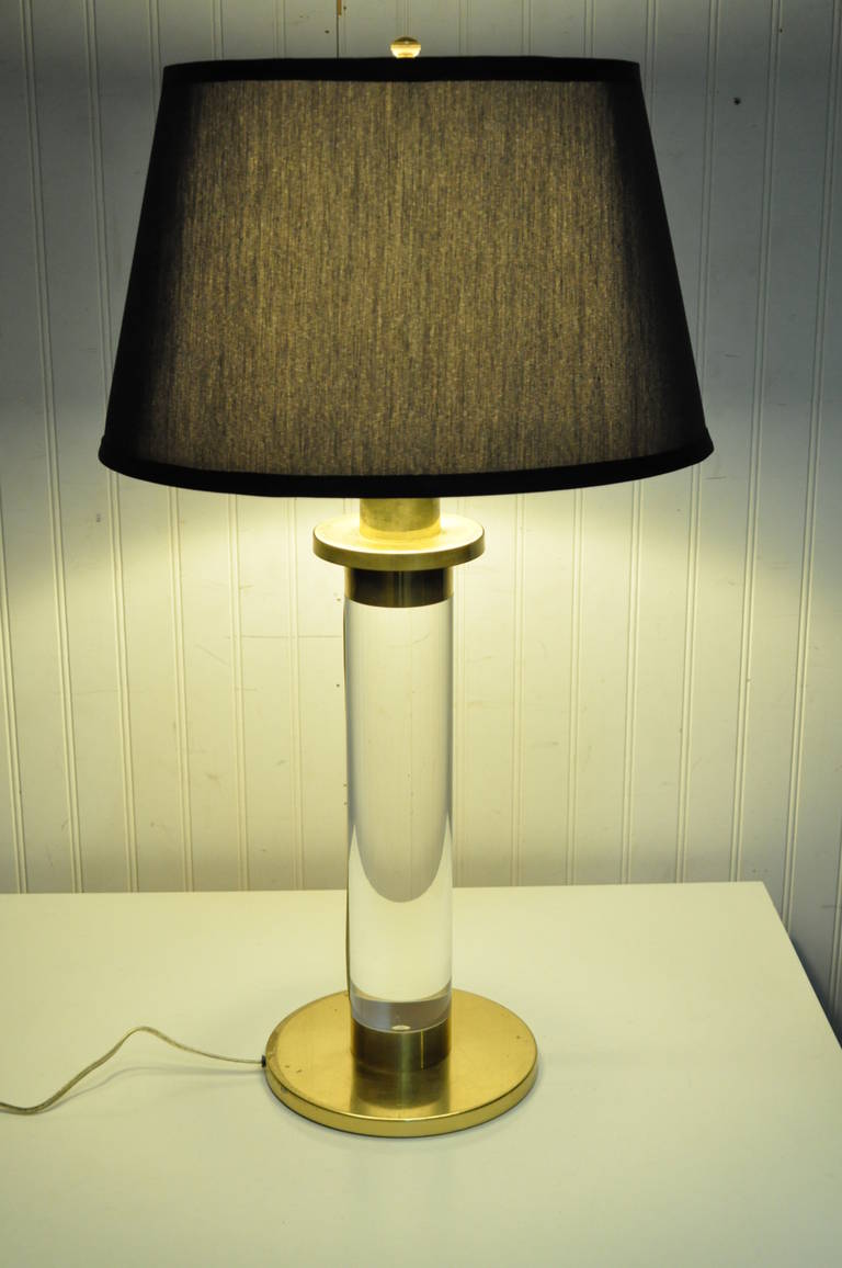 Lampe de table simple de style moderne du milieu du siècle, en lucite solide ou acrylique et laiton, à la manière de Karl Springer. Cet article moderniste rare est composé d'un corps cylindrique en lucite solide avec un capuchon en laiton et un