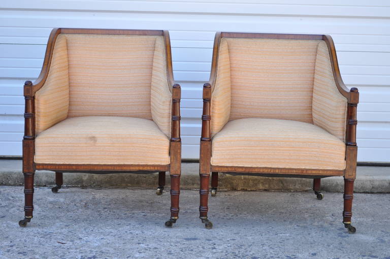 Stunning pair of antique, solid mahogany, satinwood inlaid, Regency Sheraton style arm chairs with faux bamboo form legs and arms. The pair dates back to the early 1900's and features heavy solid mahogany frames, satinwood inlay all the way around