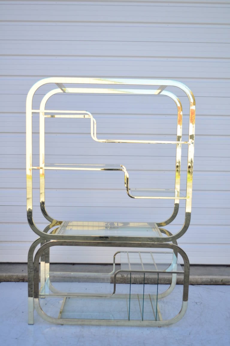 Unique Brass Plated Metal and Glass Italian Etagere with Pull Out Server by Design Institute of America. This wonderful vintage etagere / bookcase features 8 glass shelf surfaces and 3 vertical glass shelves for magazines, books, or possibly