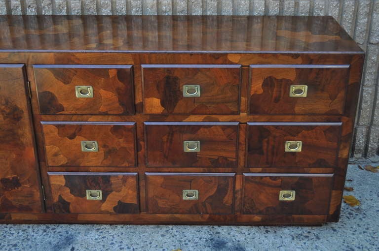 Beautiful Mid Century Modern Patchwork Burl Wood Campaign Style Credenza / Low Dresser in the Milo Baughman style by American of Martinsville. This fine chest features brass inset pulls, nine drawers, beautiful woodgrain, and great modernist form.