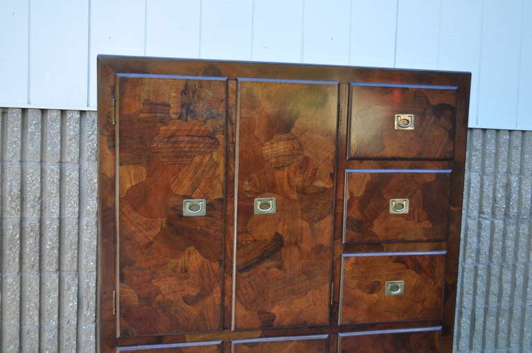 Beautiful Mid Century Modern Patchwork Burl Wood Campaign Style Tall Chest / Dresser in the Milo Baughman style by American of Martinsville. This fine chest features brass inset pulls, nine drawers, cubby storage, beautiful woodgrain, and great