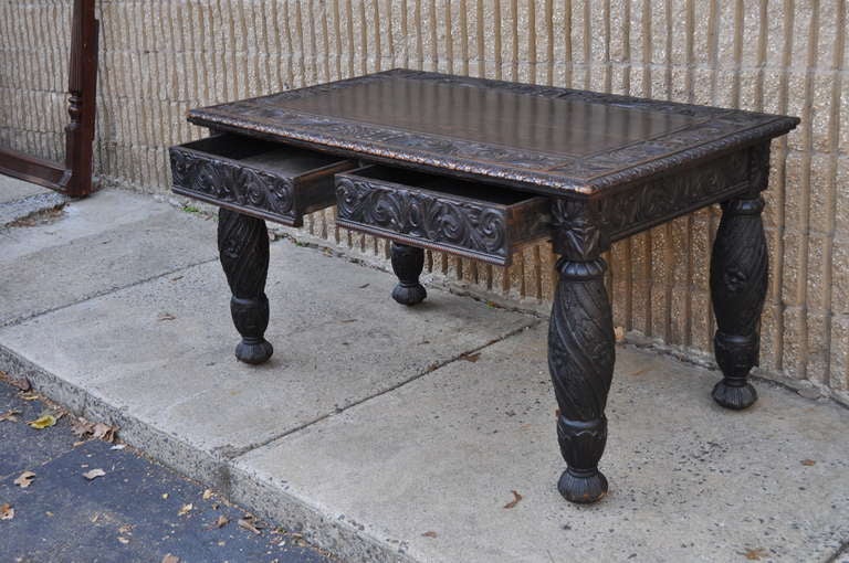 Beautiful Distressed Carved Oak Renaissance Revival / Baroque Style 2 Drawer Desk. This remarkable piece features a deeply carved skirt including the rear, finely carved turned legs, decorated top, and desirable and authentic weathering throughout