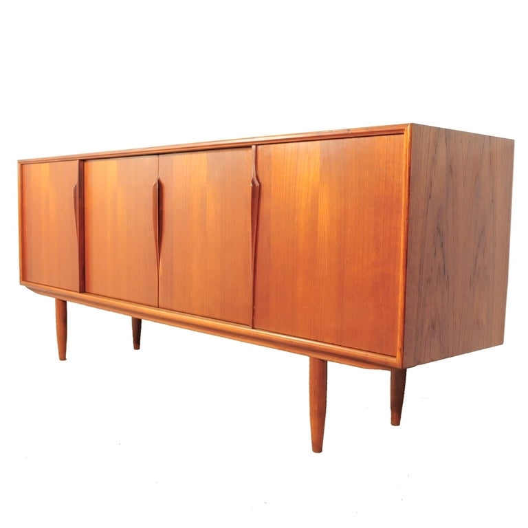 Stunning Mid Century Danish Modern Teak Sideboard/Credenza with removable bookcase top Made in Denmark by Axel Christensen for ACO Mobler. This amazing piece dates back to around the 1960's and boasts 4 lower sliding doors, bookcase top with 2